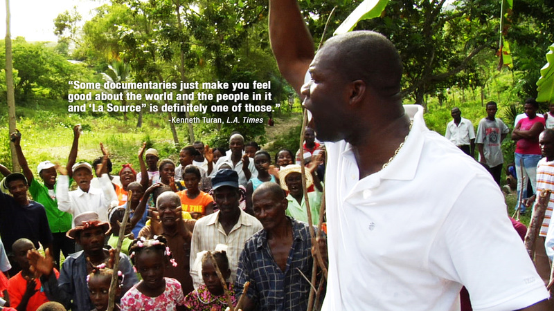 A shot from the film La Source where the main character is standing in front of the community he is helping giving a speech.