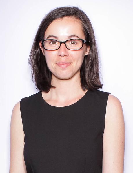 Photograph of Emily Capellari, a white woman with shoulder-length straight brown hair wearing a black dress and glasses.